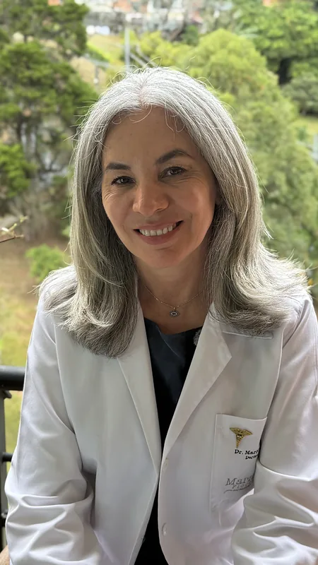 Dr Maritza Flórez in her white coat, white hair
